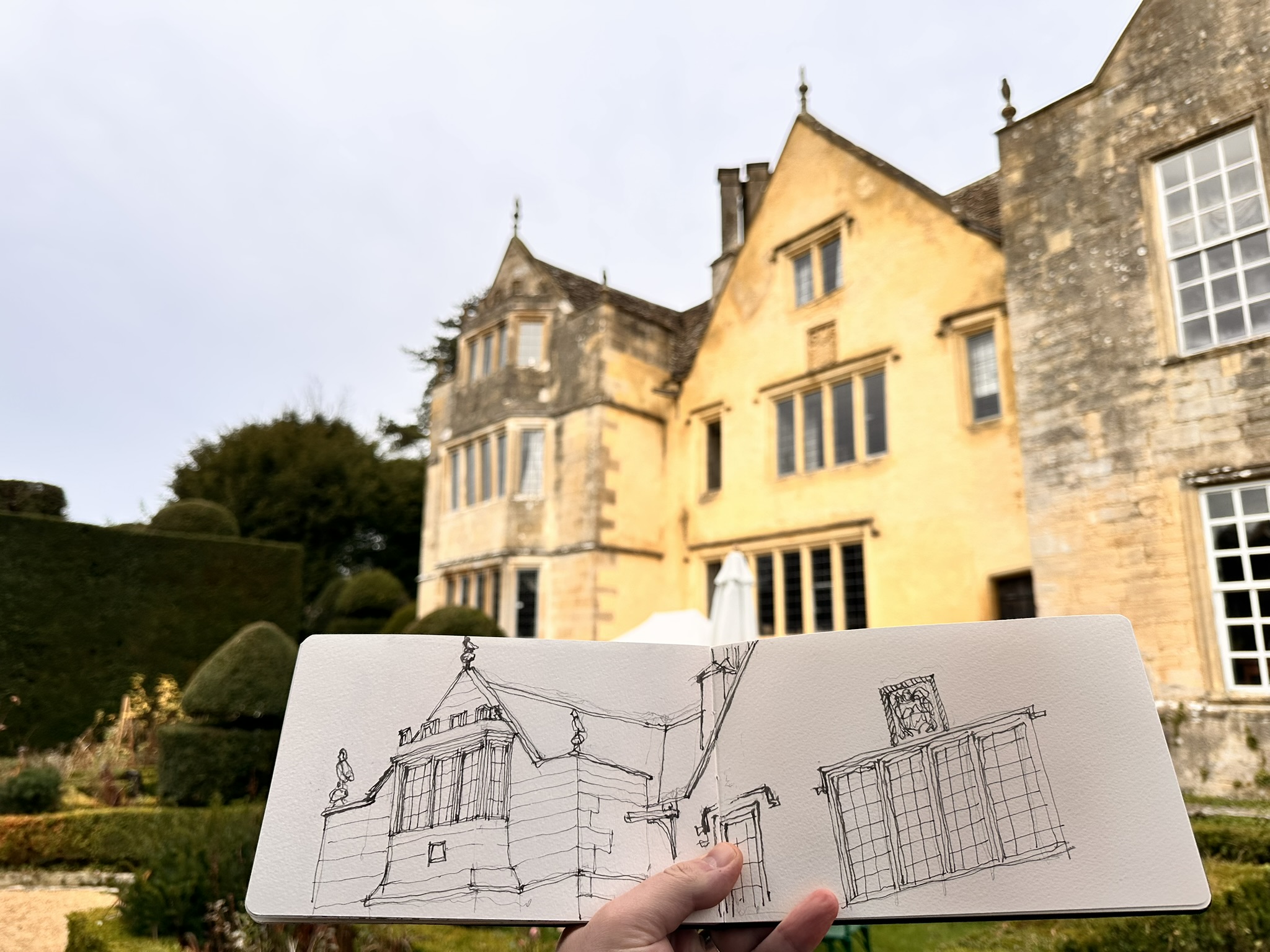 Ashley Turner sketching in front of a historic country house