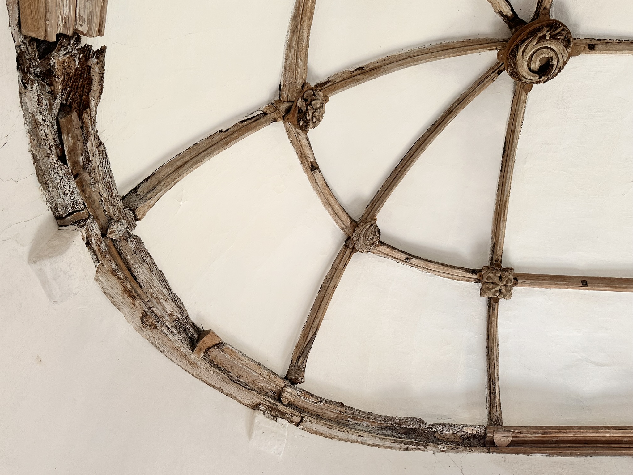 Detail of a timber vaulted ceiling with carved bosses in a historic building